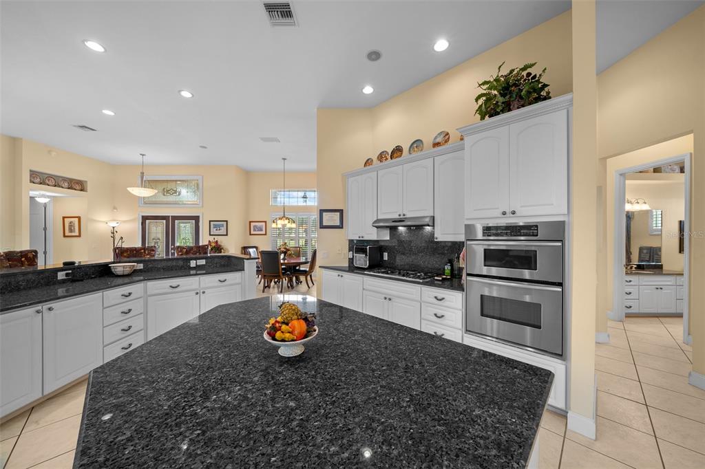 A kitchen with white cabinets, dark granite countertops, a large island, and stainless steel appliances — 5170 SE HIGHWAY 42, SUMMERFIELD, FL