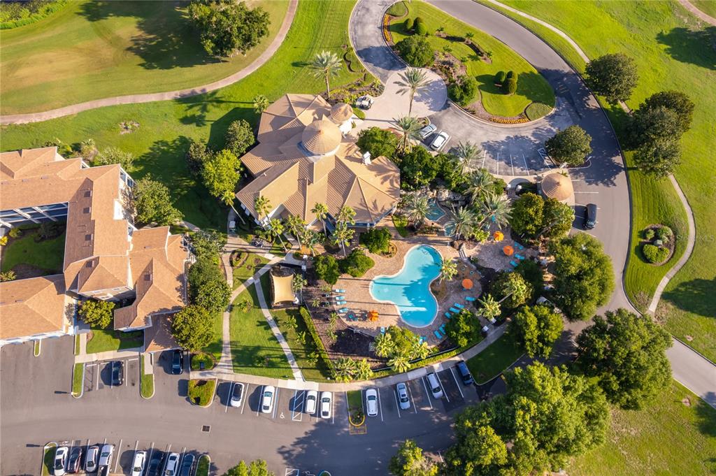 An aerial view shows a clubhouse with a swimming pool, parking lots, and surrounding landscaping — 7210 WESTPOINTE BOULEVARD UNIT 1312, ORLANDO, FL