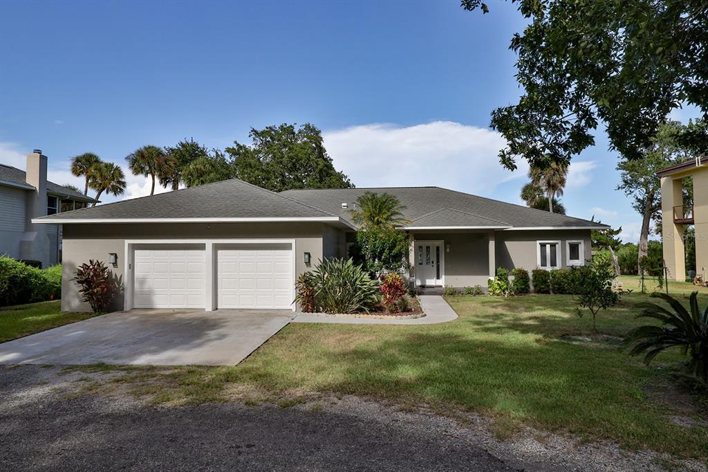 A single-story house with a two-car garage, gray exterior, and a front lawn — 2437 SWORDFISH LANE, EDGEWATER, FL