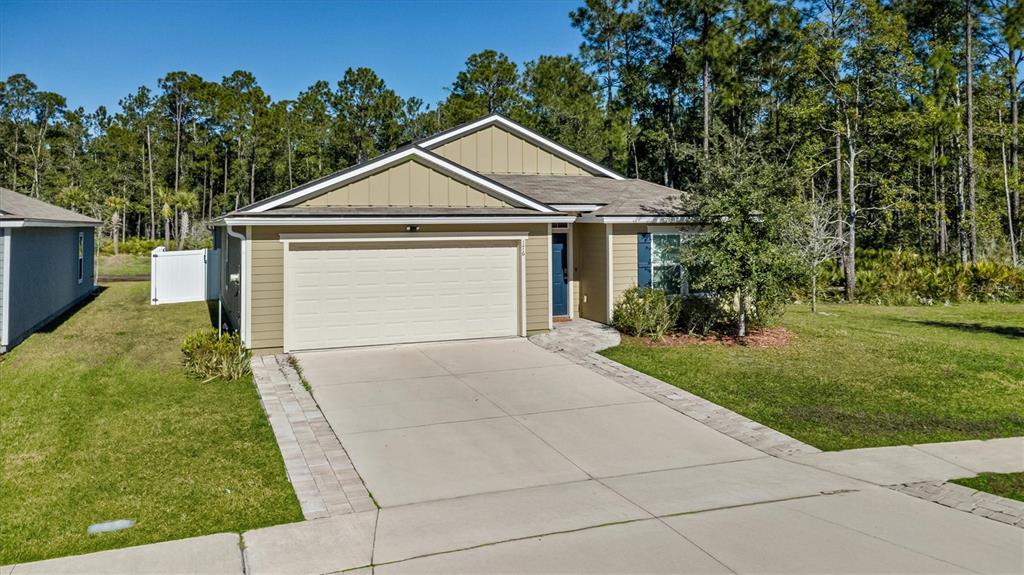 A single-story house with tan siding, a two-car garage, and a paved driveway — 176 FALCON RIDGE, ST AUGUSTINE, FL