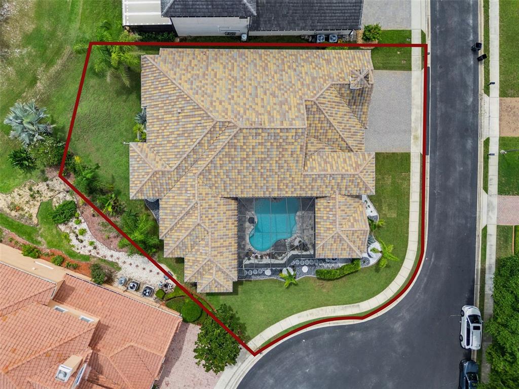 An aerial view shows a house with a tiled roof, a screened-in pool, and landscaping — 2270 CALLAWAY COURT, DAVENPORT, FL