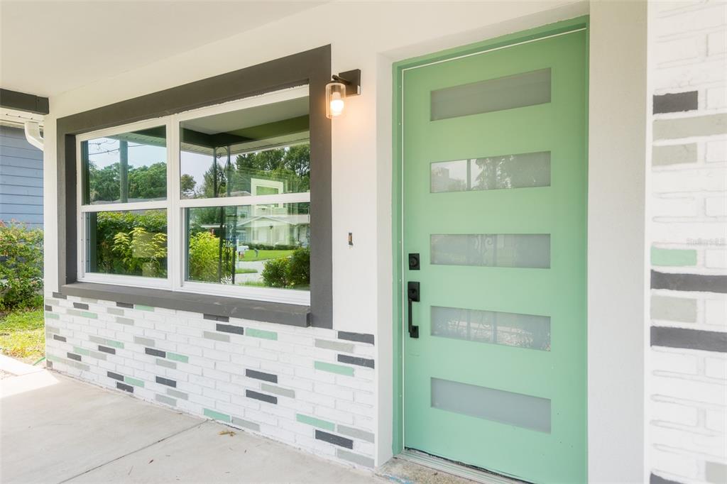 A mint green front door with horizontal glass panels sits beside a window with dark trim — 4220 W UNION STREET, TAMPA, FL