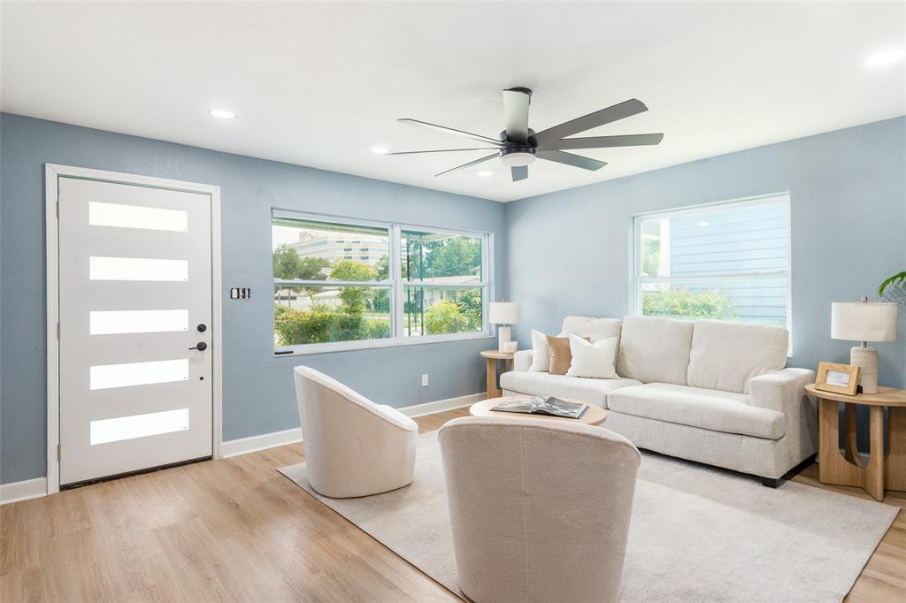 A living room features light blue walls, a white front door, and neutral-toned furniture — 4220 W UNION STREET, TAMPA, FL