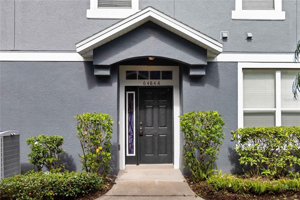 The exterior of a gray townhouse features a black front door with a side window — 6484 S GOLDENROD ROAD UNIT 41A, ORLANDO, FL