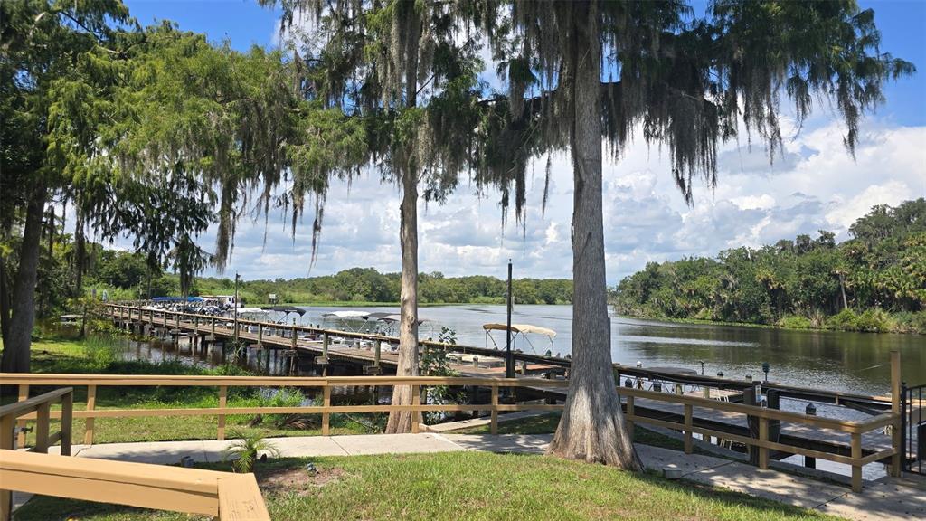 A wooden dock with boat slips extends into a river lined with moss-draped cypress trees — 213 SHER LANE UNIT 1, DEBARY, FL
