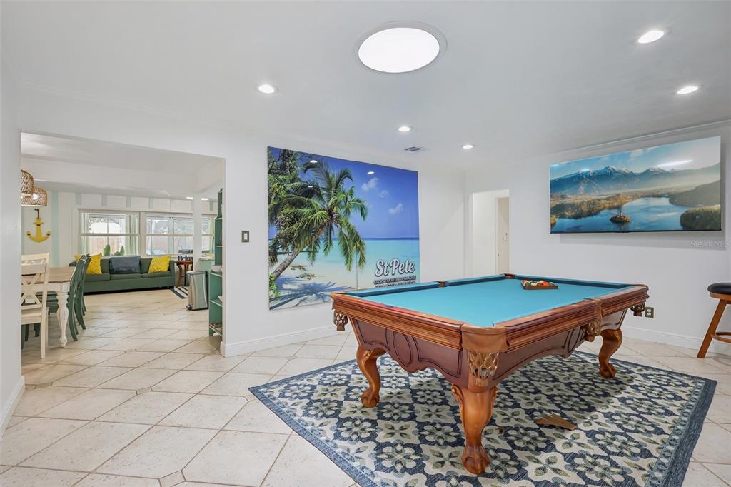 A covered front porch features teal walls, stone flooring, a wooden door, and two chairs — 13801 87TH AVENUE, SEMINOLE, FL