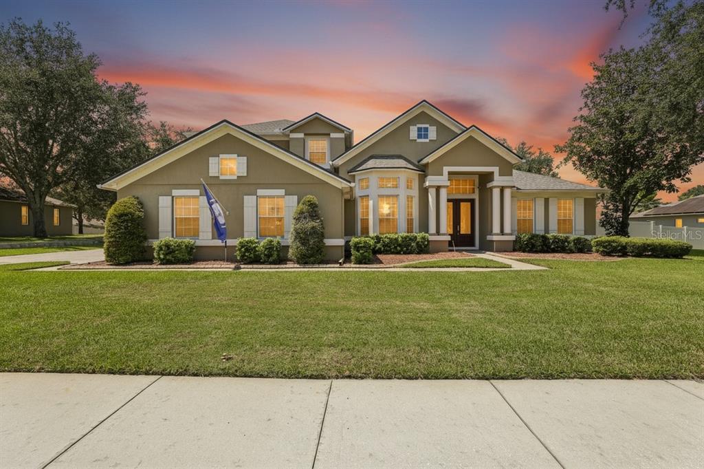 A single-story suburban house with a tan stucco exterior and a front-facing lawn — 2431 PONKAN SUMMIT DRIVE, APOPKA, FL