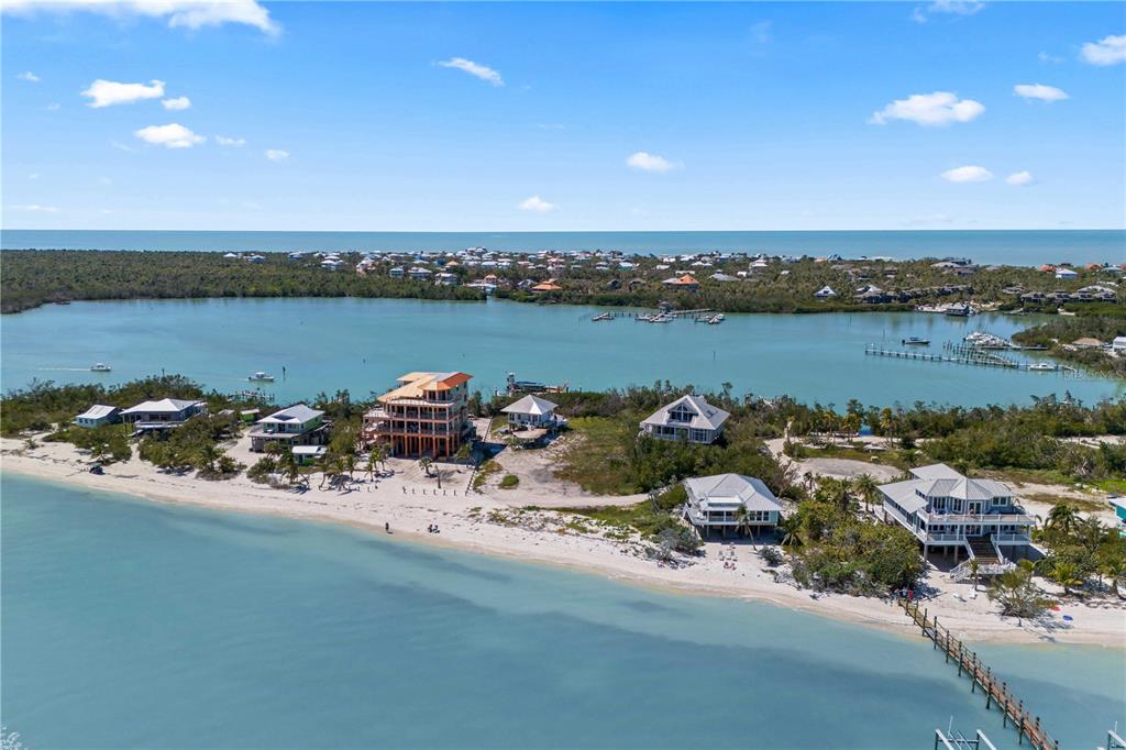 An aerial view shows several houses on a sandy beach along a coastal waterway — 4281 POINT HOUSE TRAIL, CAPTIVA, FL