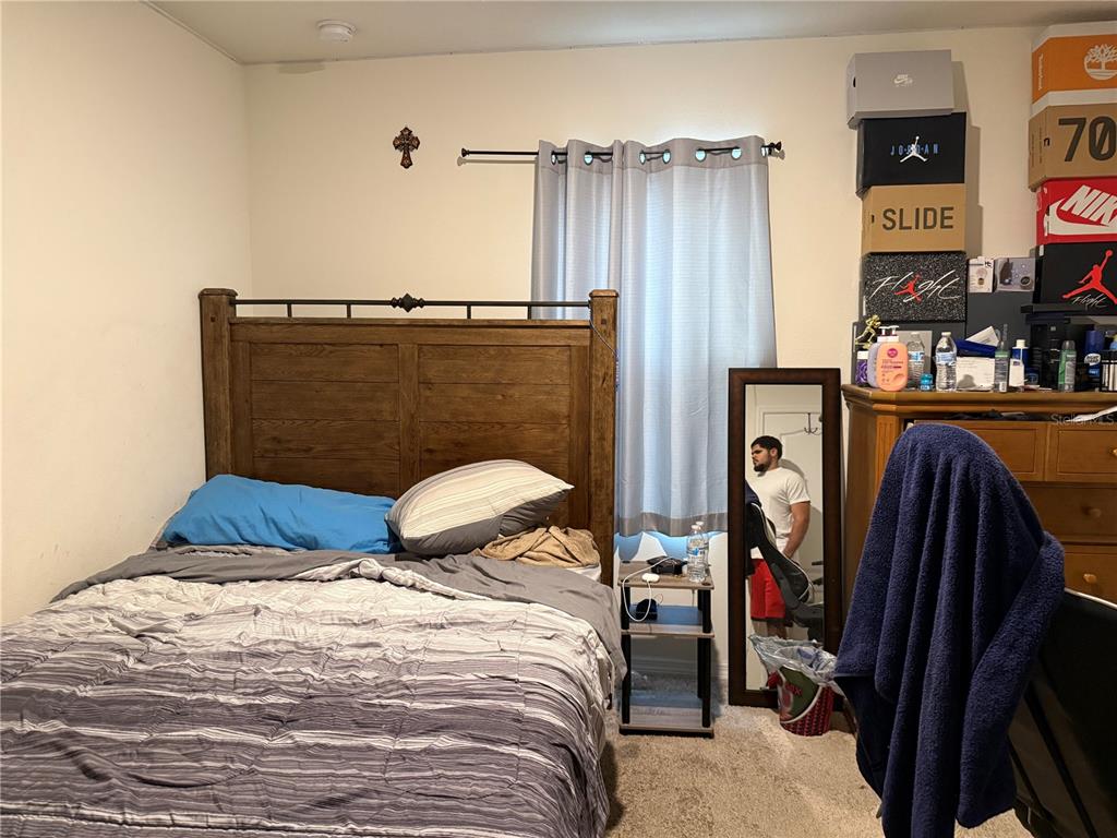 A bedroom features a wooden bed frame, a small nightstand, a mirror, and stacked shoeboxes — 3597 YARIAN, HAINES CITY, FL