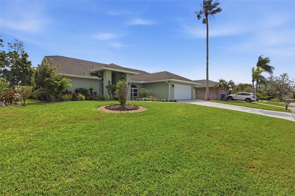 A single-story green house with a two-car garage and a large front lawn — 5207 86TH STREET COURT W, BRADENTON, FL