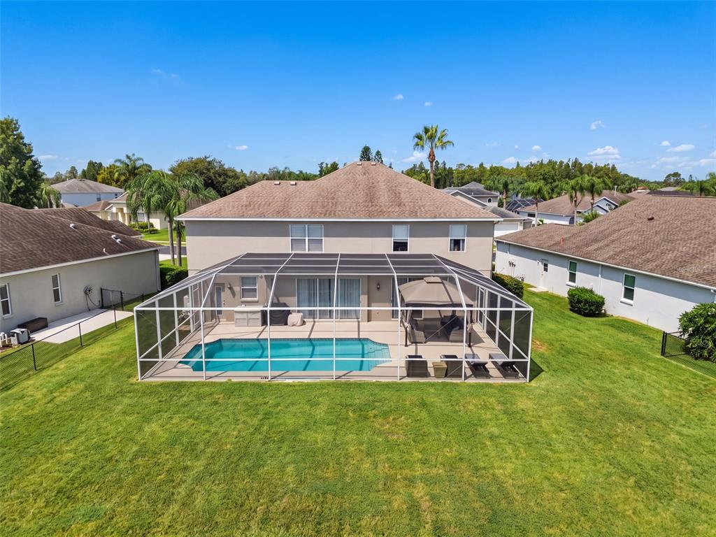 An aerial view of a house with a screened-in pool and patio in the backyard — 1900 CARDAMON DRIVE, TRINITY, FL