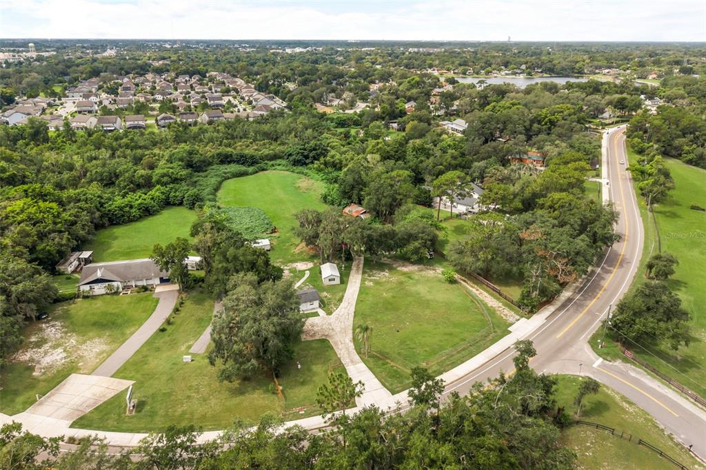 An aerial view shows a house with a long driveway on a large, grassy lot — 250 LONGWOOD HILLS ROAD, LONGWOOD, FL