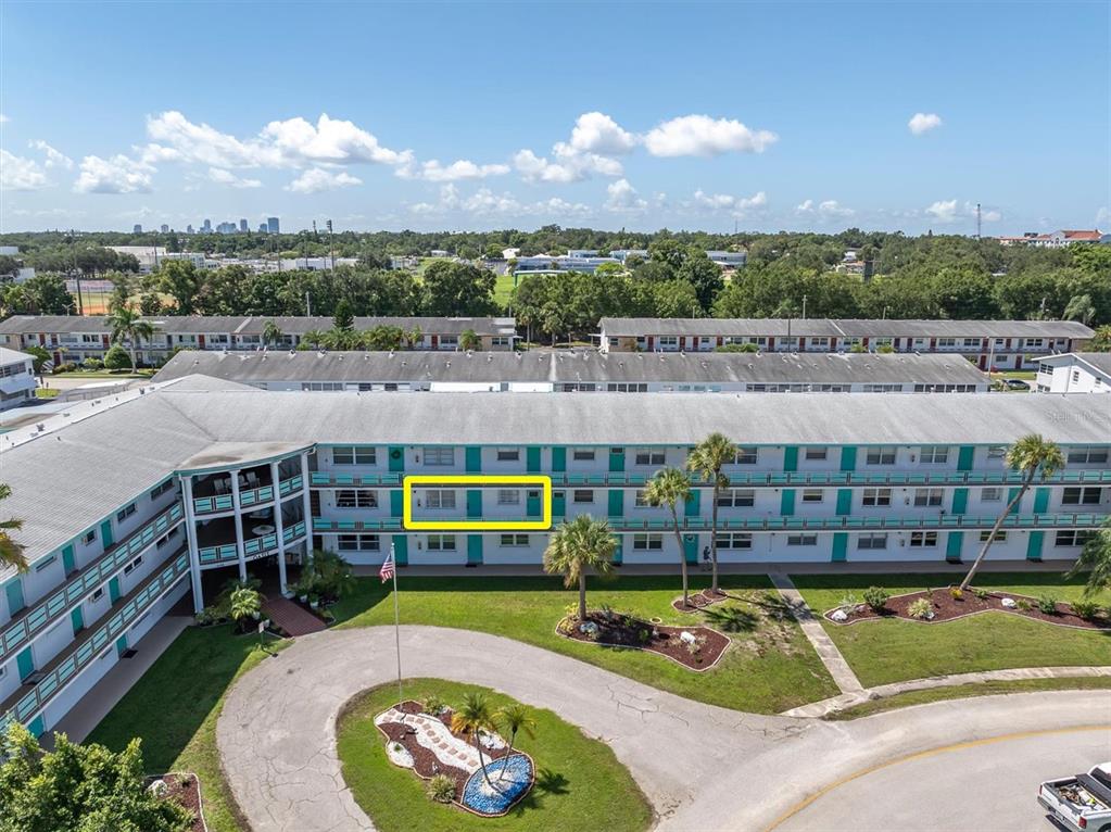 An aerial view shows a multi-story apartment building with a highlighted unit on the second floor — 1900 59TH AVENUE N UNIT 212, ST PETERSBURG, FL