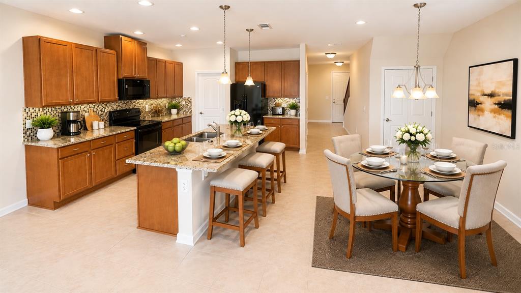A kitchen with wood cabinets and granite countertops opens into a dining area with seating — 7605 ALOMA PINES COURT, WINTER PARK, FL