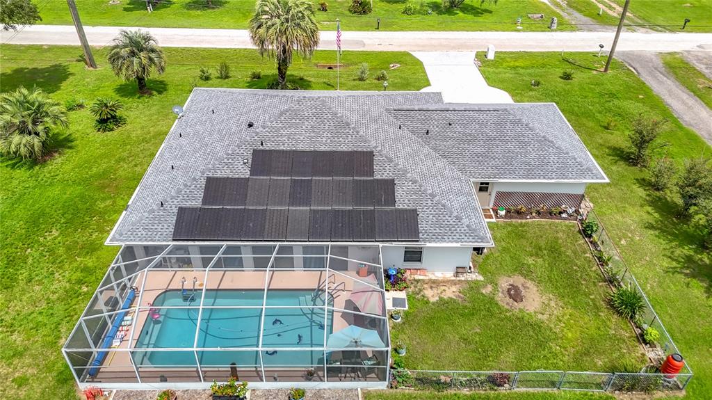 An aerial view of a house with a solar panel array and a screened-in pool — 40312 SUNBURST DRIVE, DADE CITY, FL