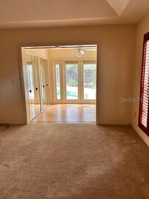 A carpeted room opens through a wide doorway to a sunroom with a swimming pool view — 8531 TULIP COURT, ORLANDO, FL