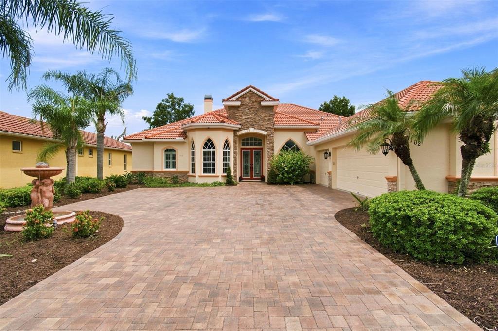 A single-story house with a stone facade, tile roof, and a paved driveway — 5102 DELACROIX DRIVE, BROOKSVILLE, FL