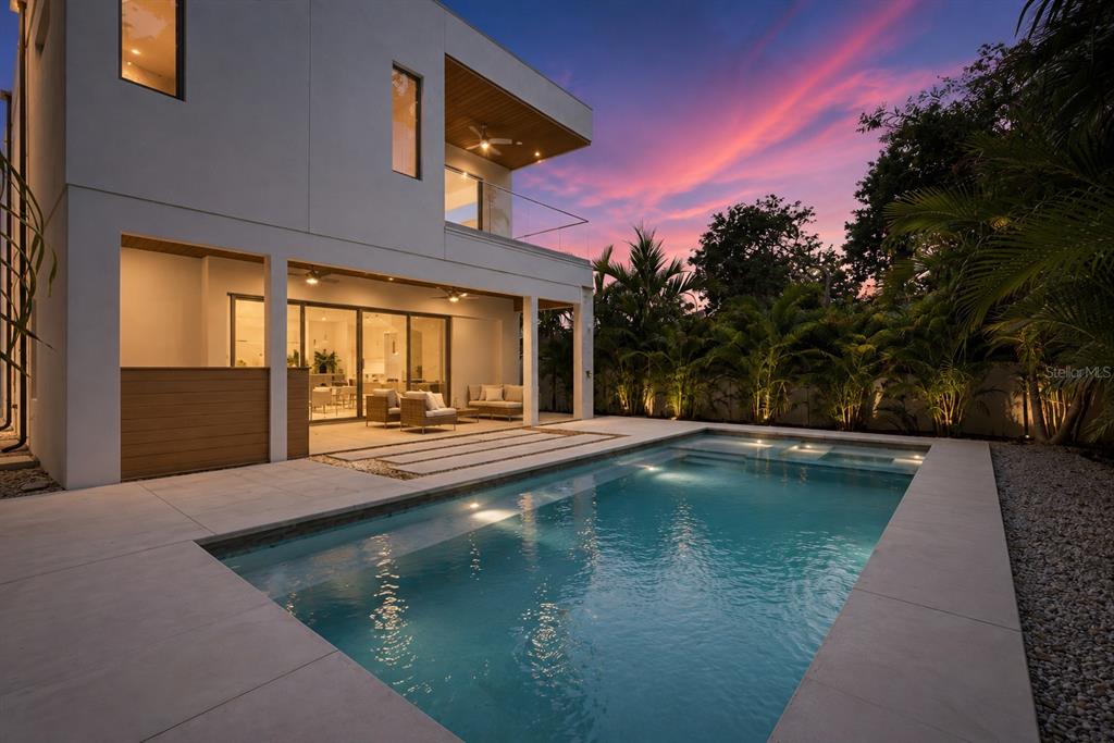 A modern two-story house with a swimming pool and patio at sunset — 1671 ARLINGTON STREET, SARASOTA, FL