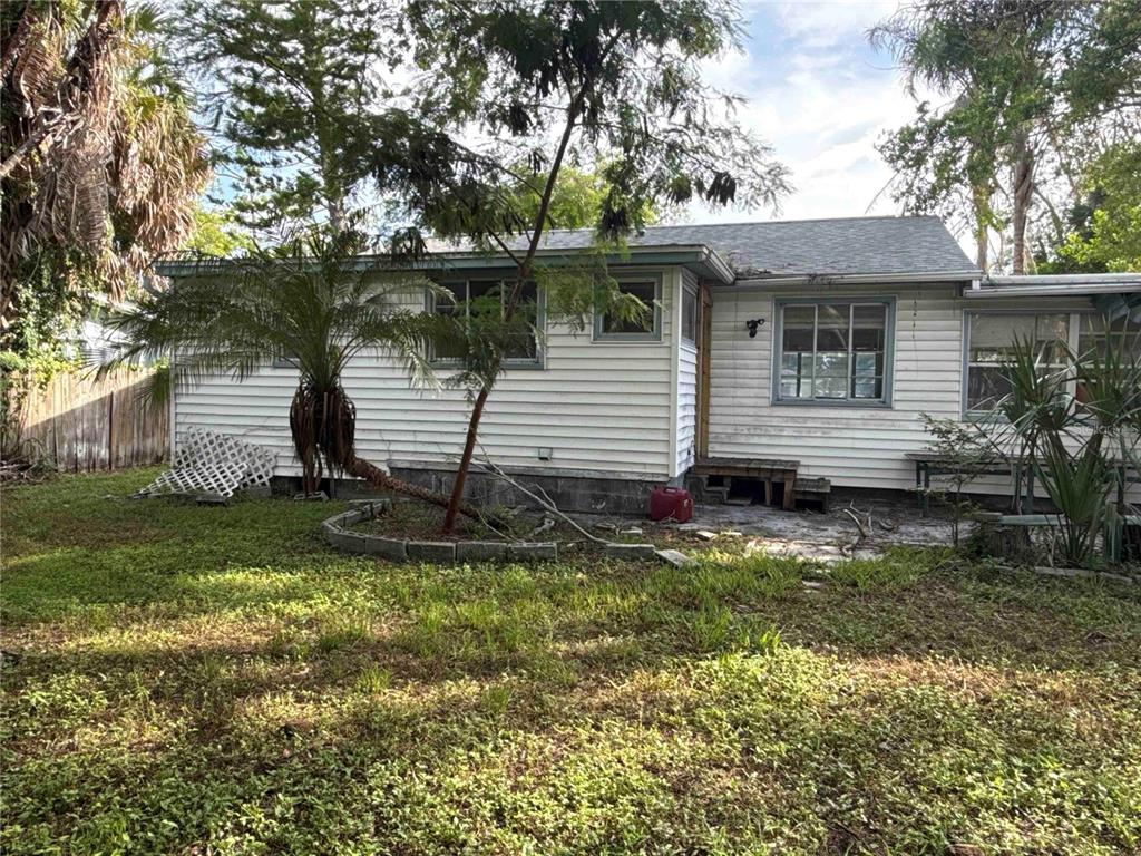 A single-story house with white horizontal siding, a shingled roof, and a grassy yard — 7011 HIBISCUS AVENUE S, SOUTH PASADENA, FL