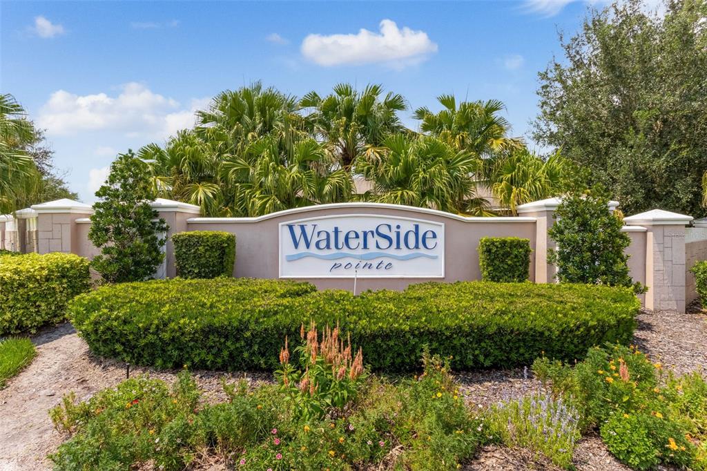 A stone monument sign for WaterSide Pointe stands behind manicured hedges and palm trees — 589 BLUE CYPRESS DRIVE, GROVELAND, FL