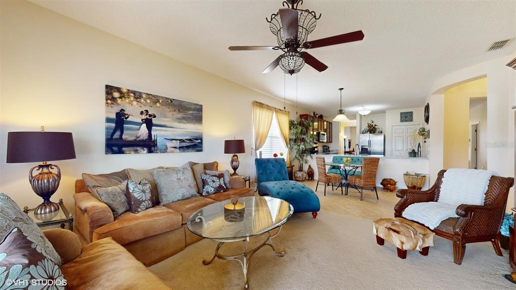 A living room features a brown sofa, a blue chaise lounge, and a glass coffee table — 321 CRESSA CIRCLE, COCOA, FL