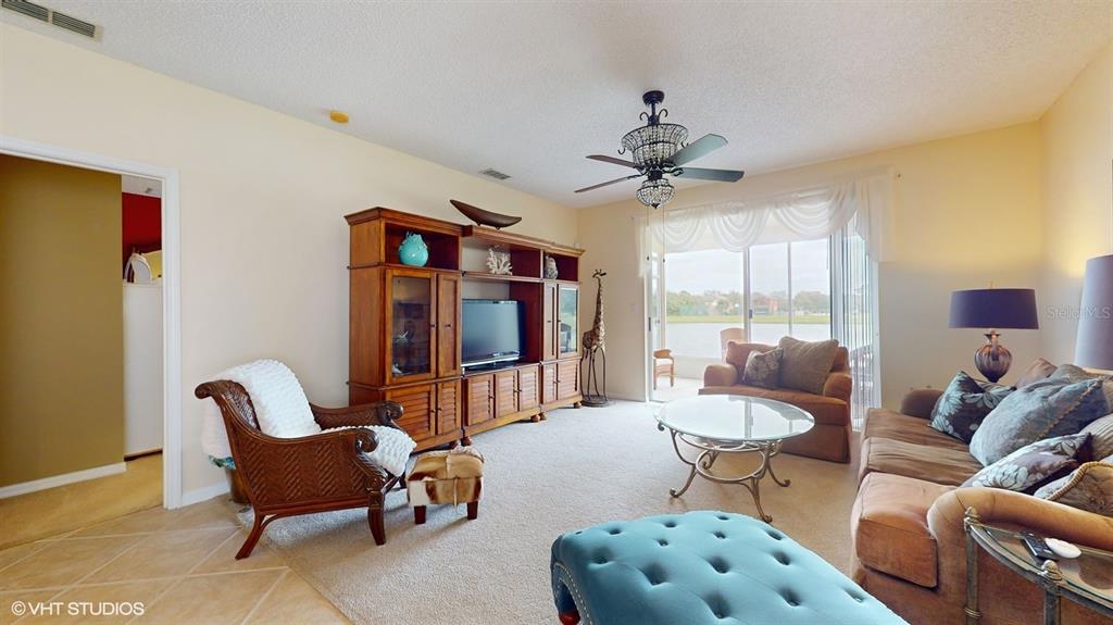A living room features a large wooden entertainment center, a ceiling fan, and sliding doors — 321 CRESSA CIRCLE, COCOA, FL