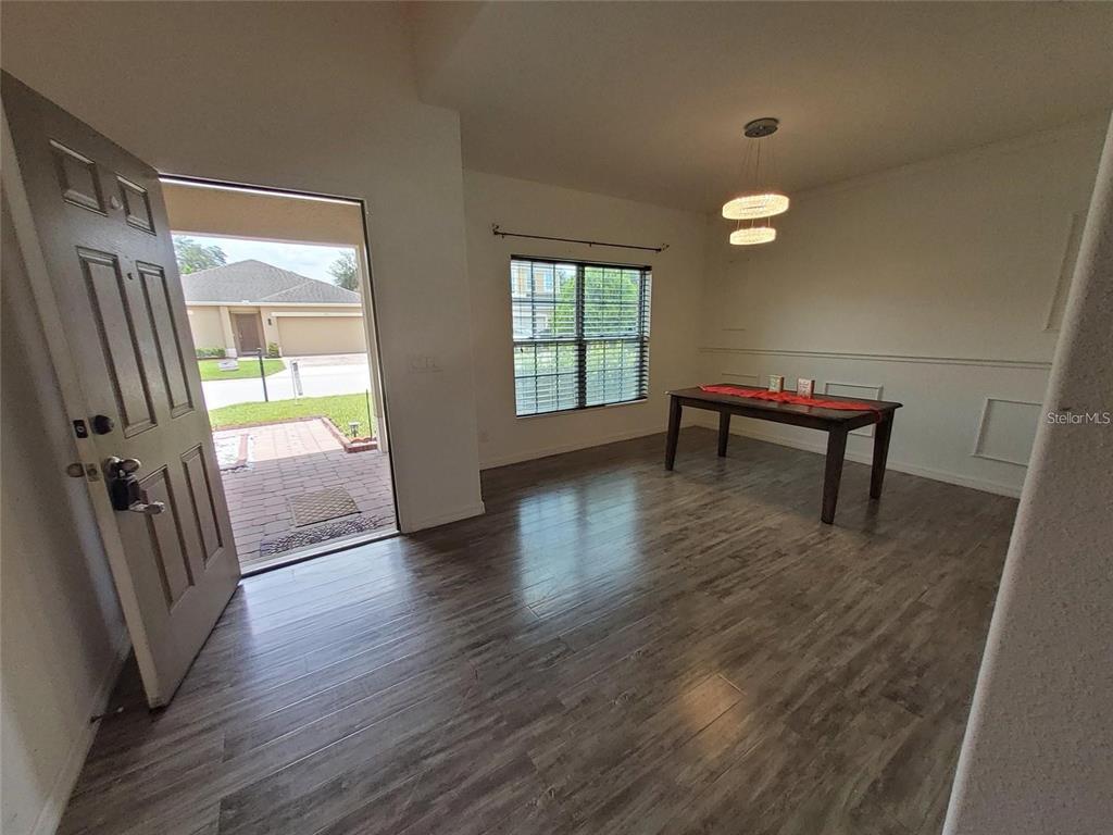 An entryway leads into a dining area with wood-look flooring and a modern pendant light — 355 GRANADA BOULEVARD, DAVENPORT, FL