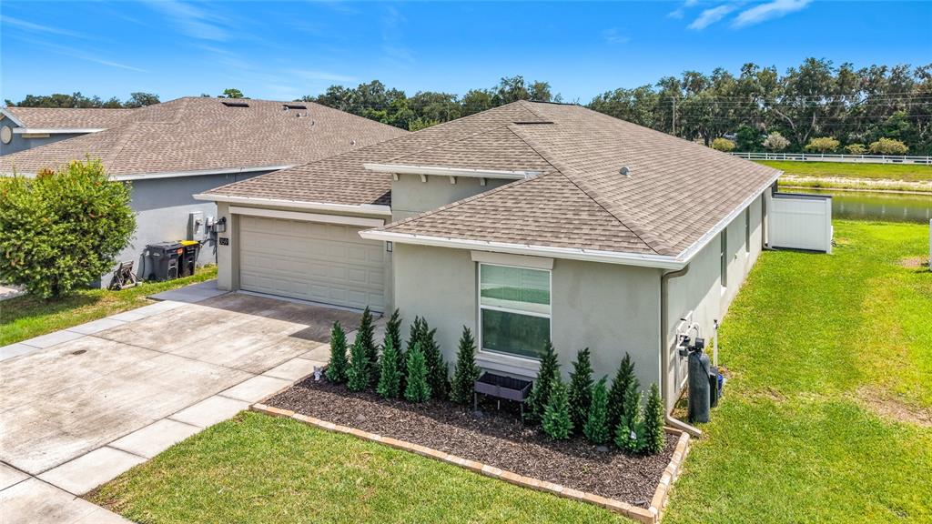 An exterior view of a single-story house with a garage, landscaping, and a side yard — 359 MACARTHUR STREET, BARTOW, FL