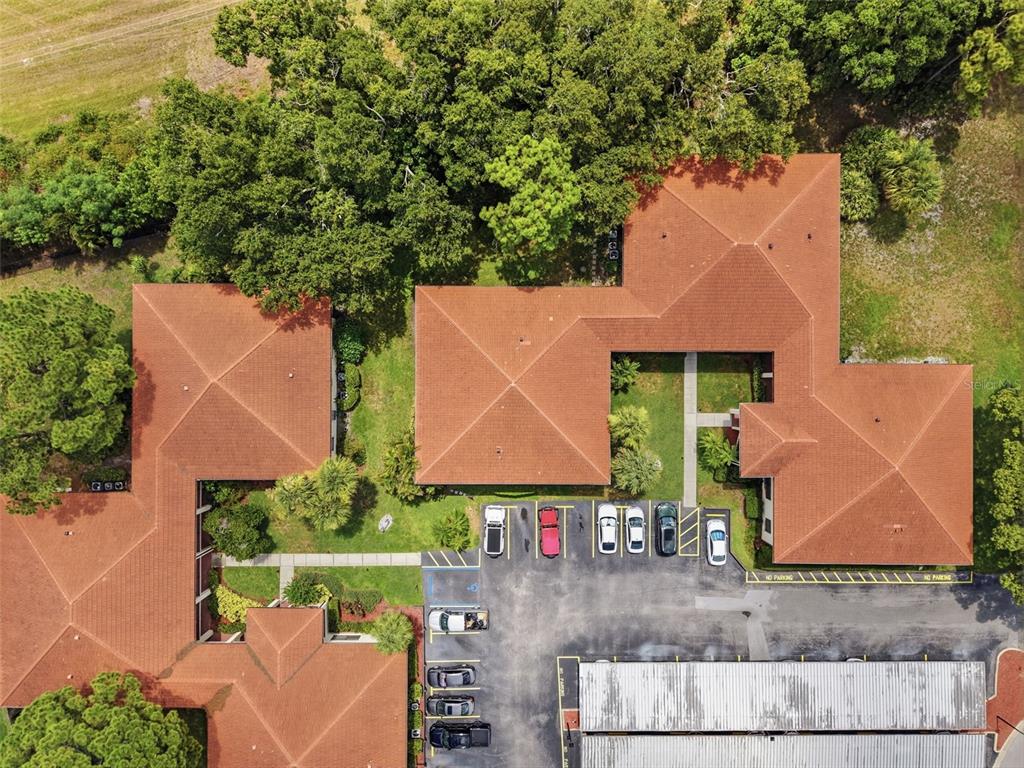 An aerial view shows a multi-wing building with a red tile roof and parking lot — 1309 HAMMOCK PINE BOULEVARD UNIT 1309, CLEARWATER, FL