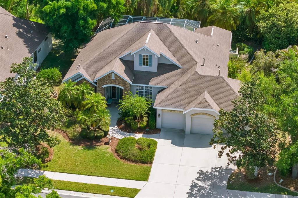An aerial view of a single-story house with a shingled roof and a two-car garage — 3839 59TH AVENUE CIRCLE E, ELLENTON, FL