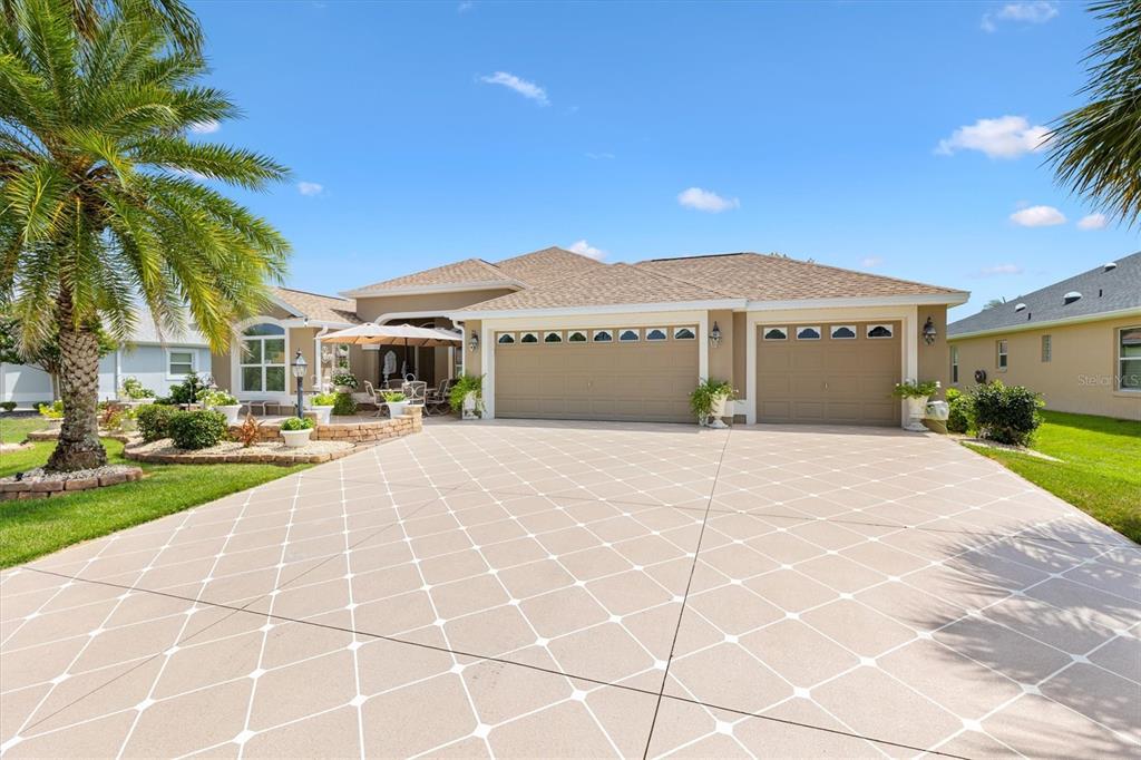 A single-story house with a three-car garage and a patterned concrete driveway — 2493 BACHMAN PATH, THE VILLAGES, FL