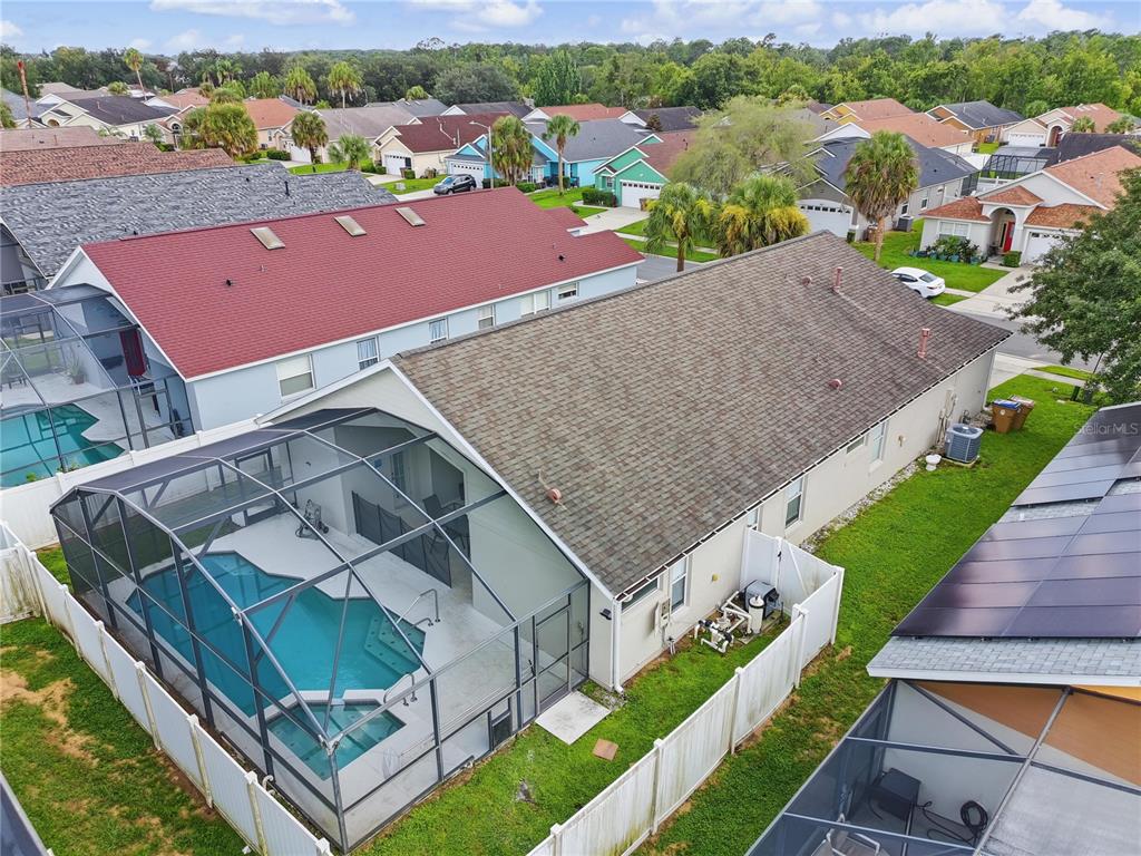 An aerial view shows a house with a screened-in pool and a fenced backyard — 8105 SANTEE DRIVE, KISSIMMEE, FL