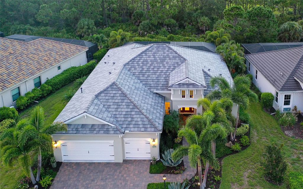 An aerial view of a single-story house with a gray tile roof and paved driveway — 26599 RAPHIS ROYALE BOULEVARD, ENGLEWOOD, FL