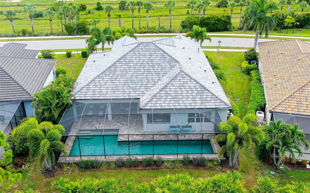 An aerial view of a house with a screened-in pool and a gray tiled roof — 26599 RAPHIS ROYALE BOULEVARD, ENGLEWOOD, FL