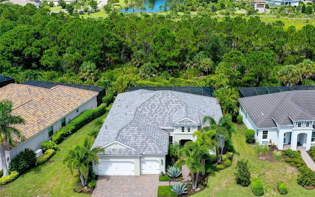 An aerial view shows a single-story house with a gray tiled roof and two-car garage — 26599 RAPHIS ROYALE BOULEVARD, ENGLEWOOD, FL