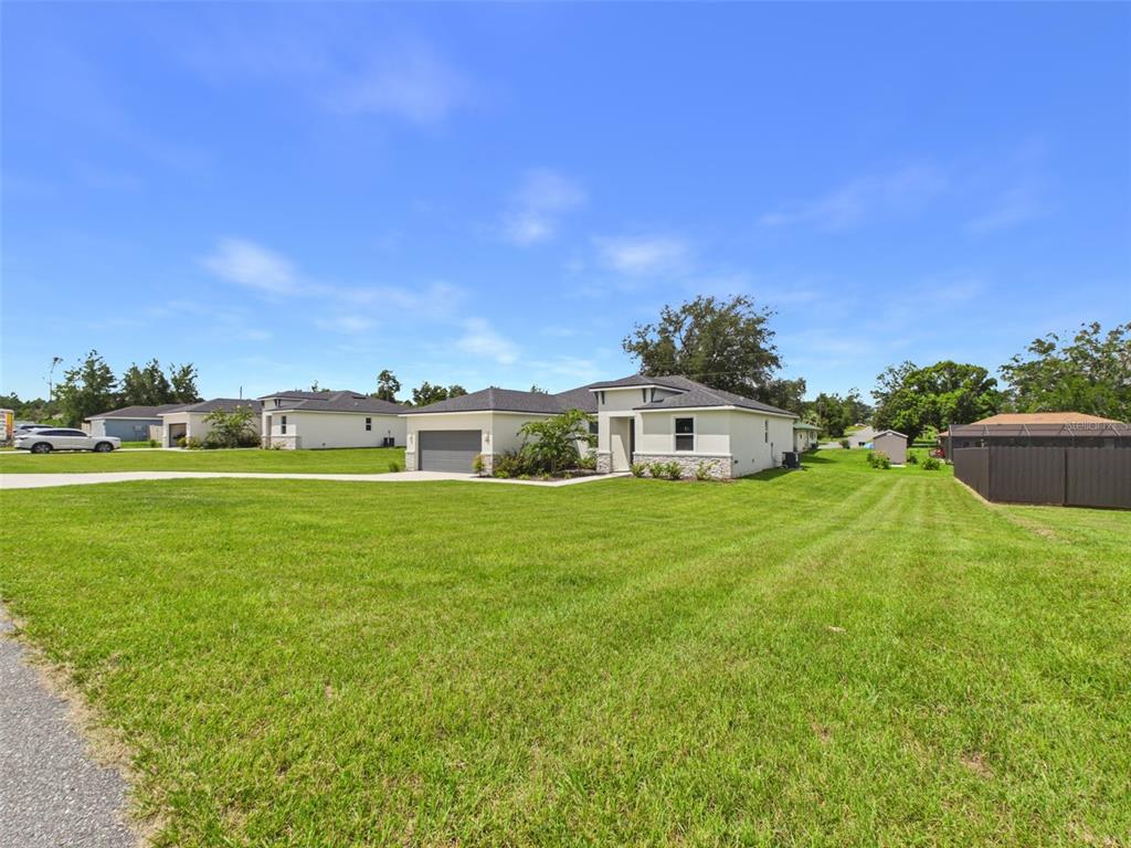 A single-story house with a gray garage, light-colored stucco, and stone accents — 16090 SW 42ND TERRACE, OCALA, FL