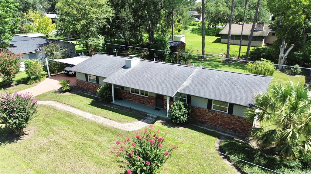 An aerial view of a single-story brick and siding house with a covered carport — 1815 SE 7TH AVENUE, OCALA, FL