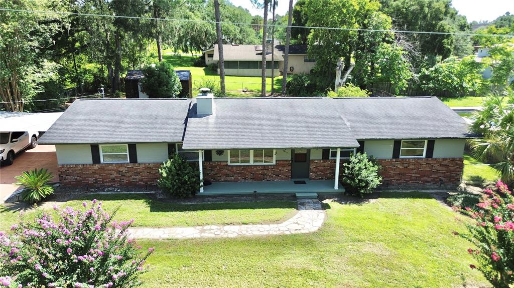 An aerial view of a single-story ranch-style house with a brick facade and gray siding — 1815 SE 7TH AVENUE, OCALA, FL