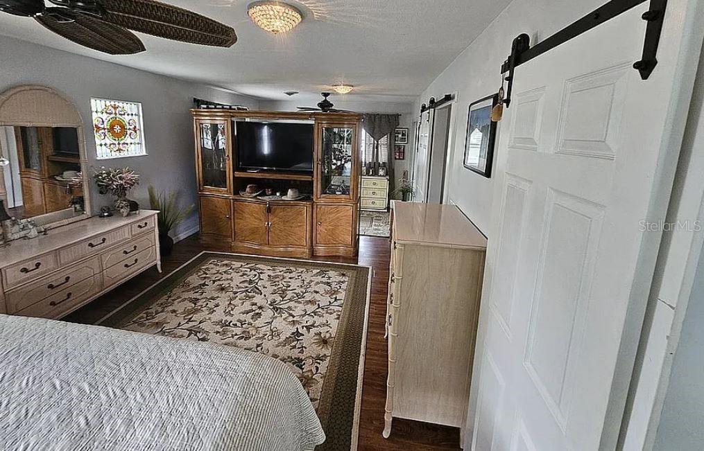An open-concept living and dining area features wood flooring, a brick fireplace, and kitchen seating — 1815 SE 7TH AVENUE, OCALA, FL