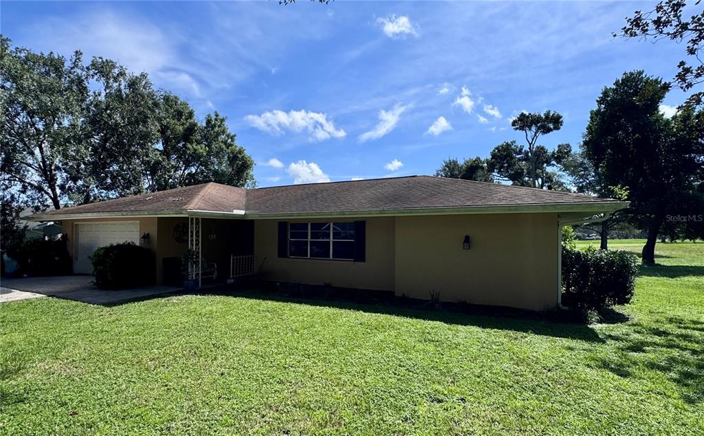 A single-story house with a tan exterior, a brown roof, and a front-facing garage — 6088 FAIRWAY DRIVE, RIDGE MANOR, FL