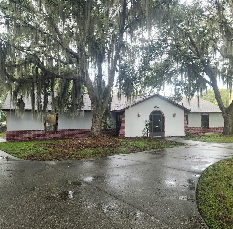 A kitchen with white cabinets, stainless steel appliances, patterned tile backsplash, and light-colored floor tiles — 2805 LAKE TOHOPEKALIGA BOULEVARD, KISSIMMEE, FL