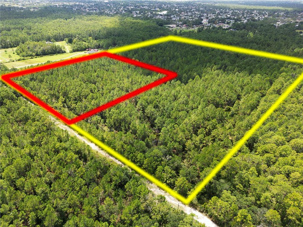 An aerial view shows a large, wooded plot of land outlined in yellow and red — 2220 OLD TRAIN ROAD, DELTONA, FL