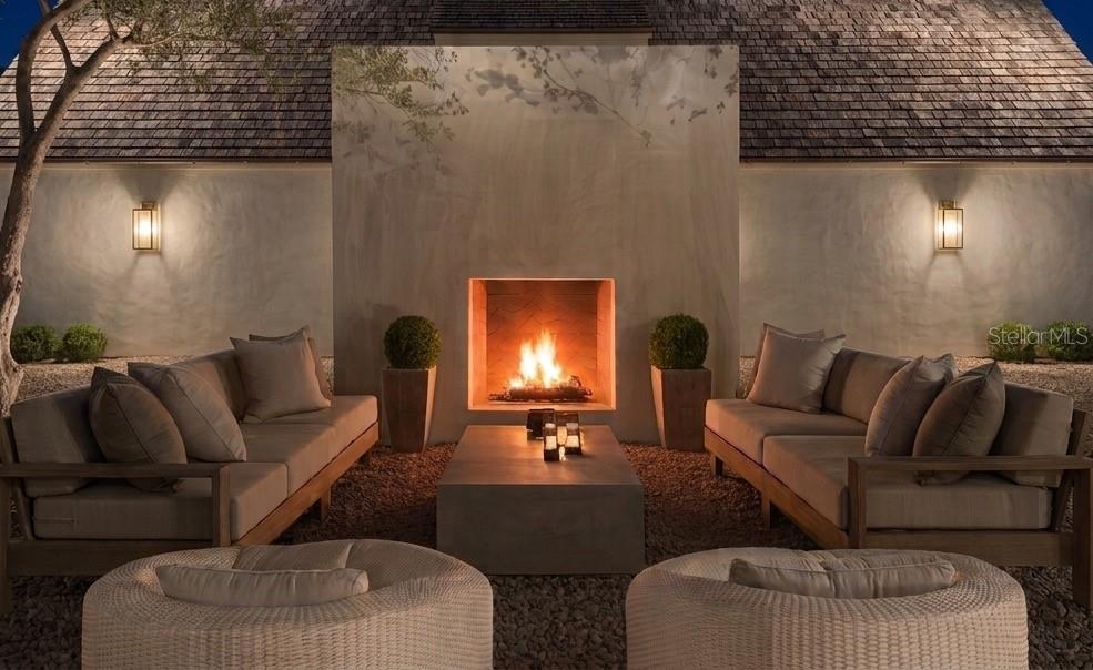 An outdoor seating area features two sofas and two chairs arranged around a central fireplace — 826 32ND AVENUE N, ST PETERSBURG, FL
