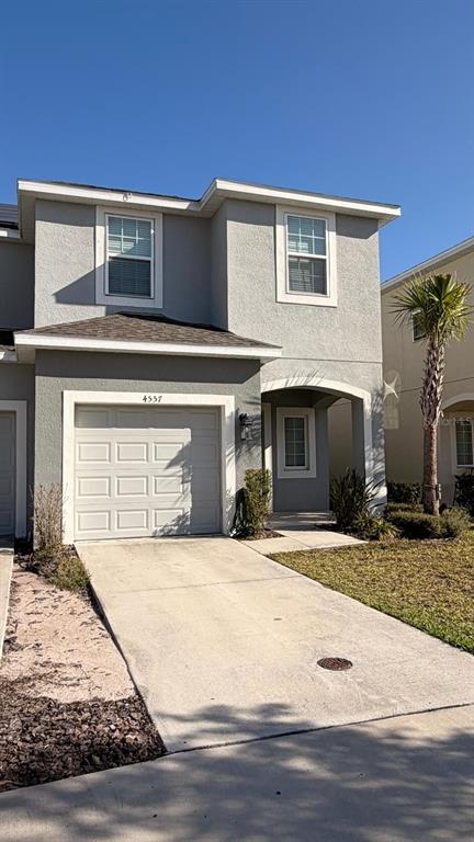 A two-story gray house features a single-car garage and a covered entryway — 4557 TEOLI COURT, KISSIMMEE, FL