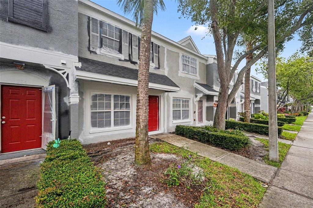 A row of townhouses with red doors and gray stucco exteriors under construction — 366 COUNTRYSIDE KEY BOULEVARD, OLDSMAR, FL