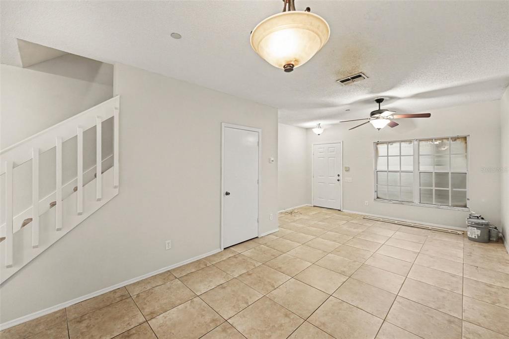 An interior view of a room with tiled floors, a staircase, and a ceiling fan — 366 COUNTRYSIDE KEY BOULEVARD, OLDSMAR, FL
