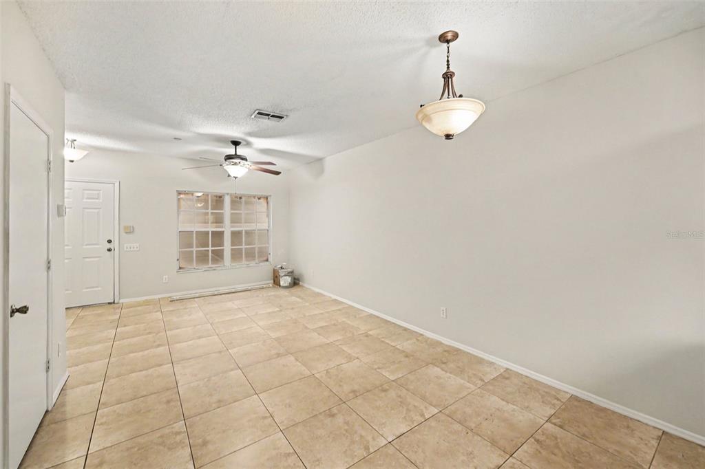 An empty room with beige tile flooring, a ceiling fan, and a hanging light fixture — 366 COUNTRYSIDE KEY BOULEVARD, OLDSMAR, FL