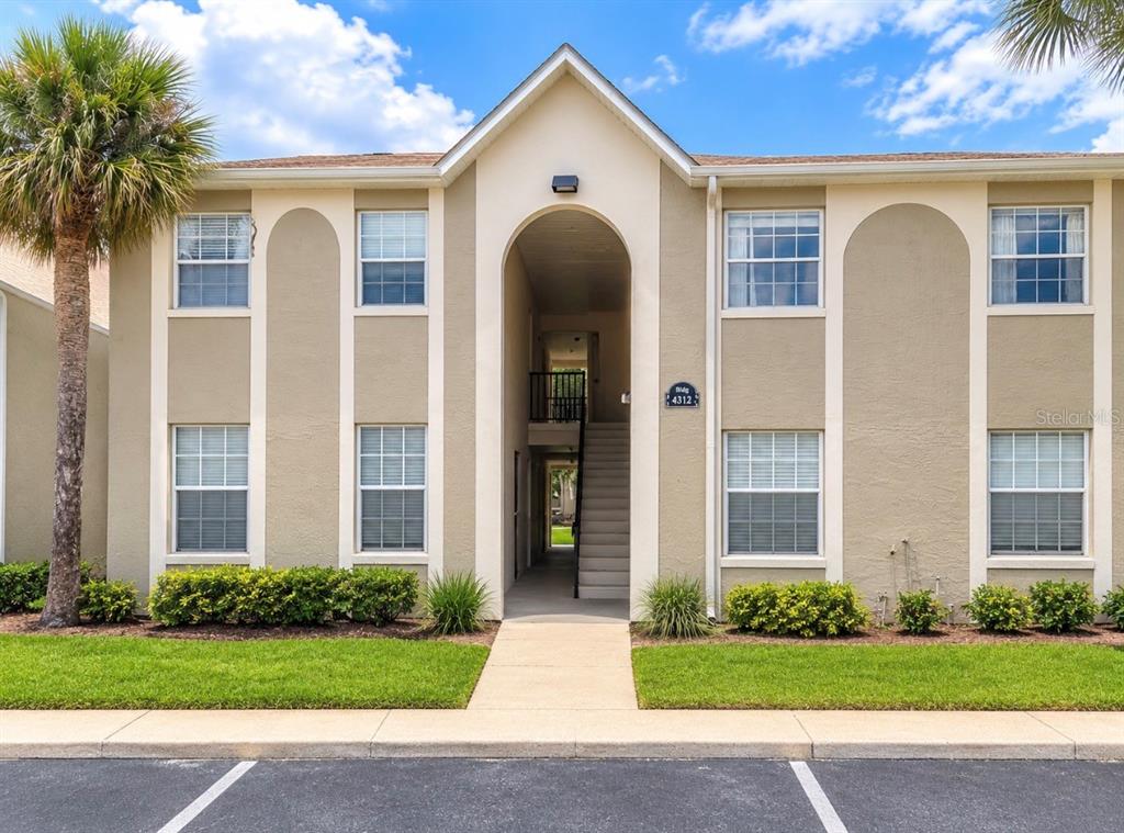 A kitchen with wood cabinets, stainless steel appliances, a double sink, and tile flooring — 4312 HECTOR COURT UNIT 4, ORLANDO, FL