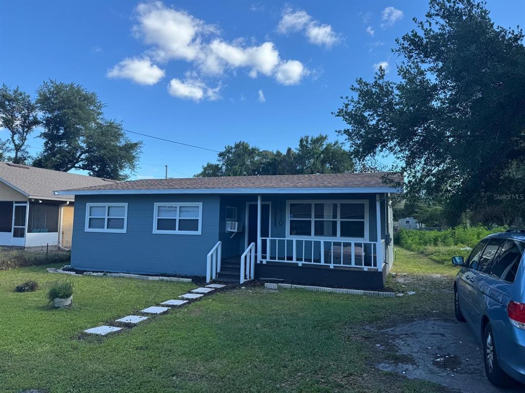 A light blue electric SUV is parked in the driveway in front of a house — 4910 HUPPEL AVENUE, ORLANDO, FL