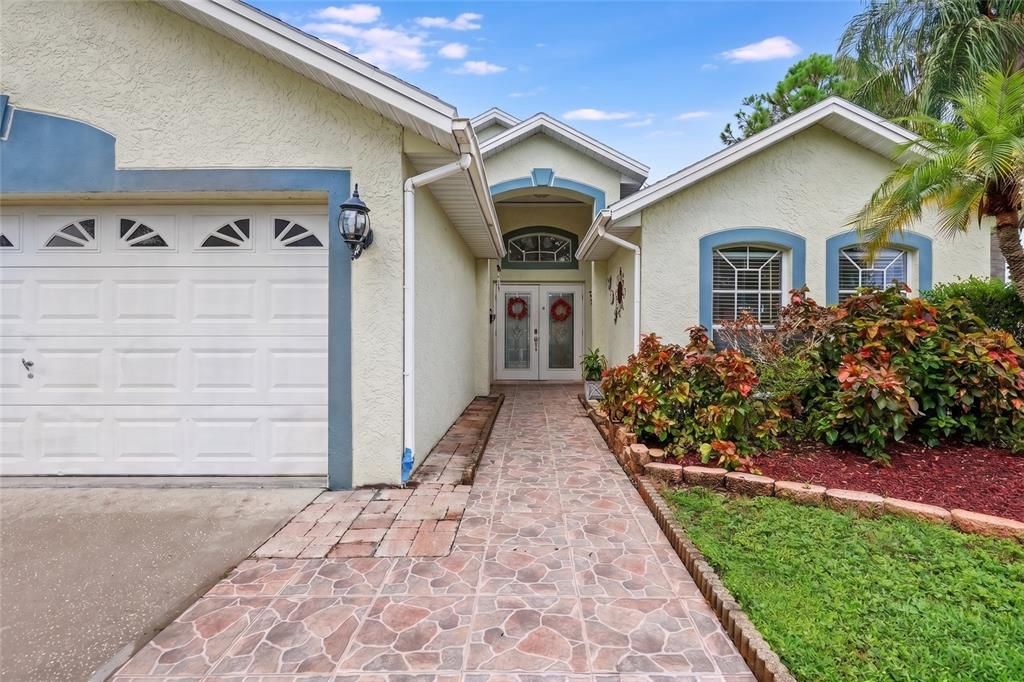 A single-story house with a white garage, stone-patterned walkway, and double front doors — 1102 VINETREE DRIVE, BRANDON, FL